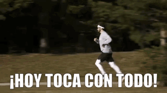 a man is running in a park with the words hoy toca con todo