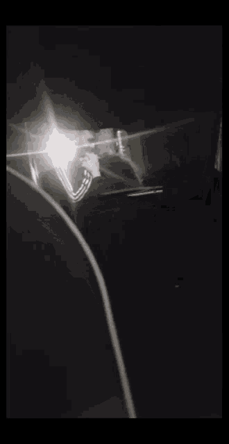 a person is taking a picture of themselves in a mirror in a dark room .
