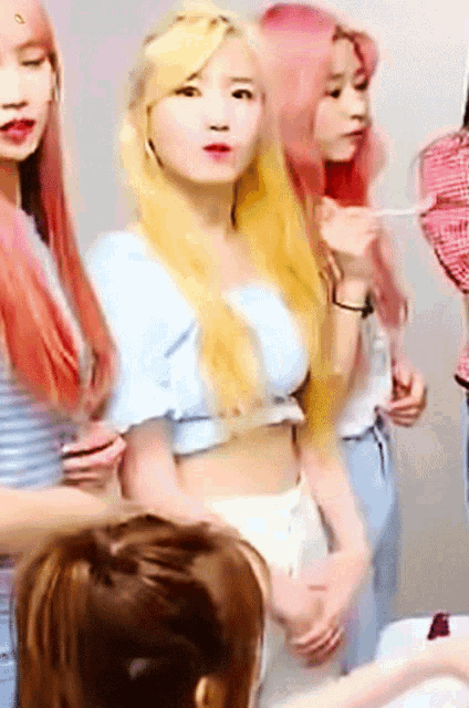 a group of girls with pink hair are standing together