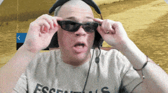 a man wearing sunglasses and a essentials shirt
