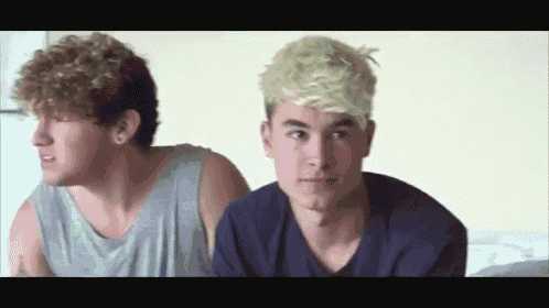 two young men are sitting next to each other and one of them has blonde hair
