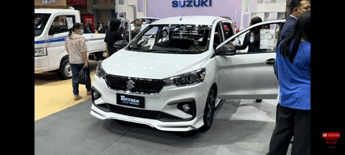 a white suzuki car is on display at a show