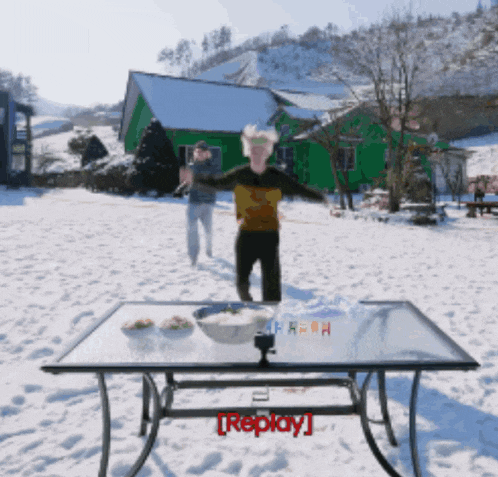 a table in the snow with replay written on it
