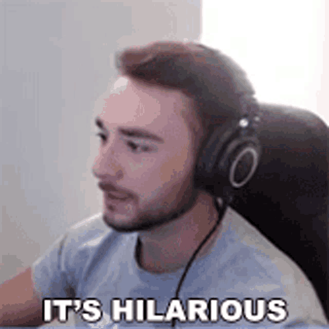a man wearing headphones is sitting in a chair and says `` it 's hilarious '' .