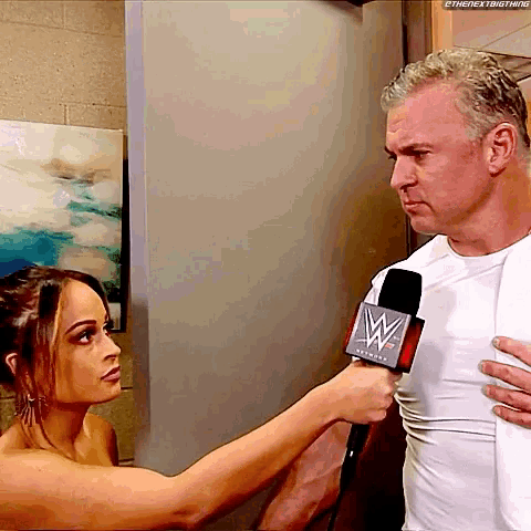 a woman is interviewing a man with a microphone that says wwe