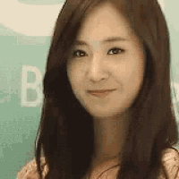 a woman with long brown hair is smiling for the camera .