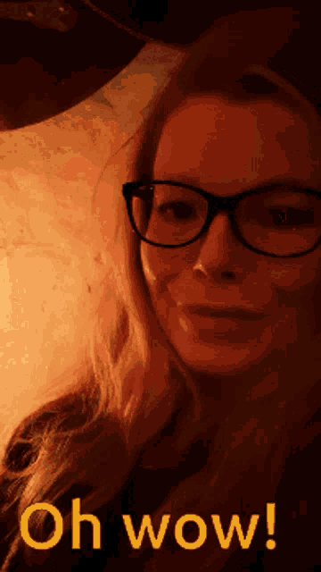 a woman wearing glasses says oh wow in yellow