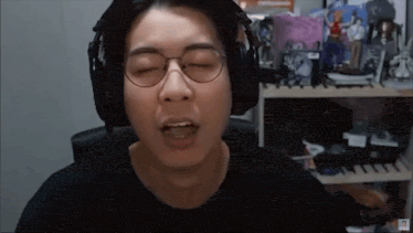 a man wearing headphones and glasses is making a face .