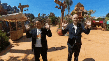 two men in suits are waving in front of a sign that says dr.