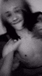 a black and white photo of a shirtless man and a woman