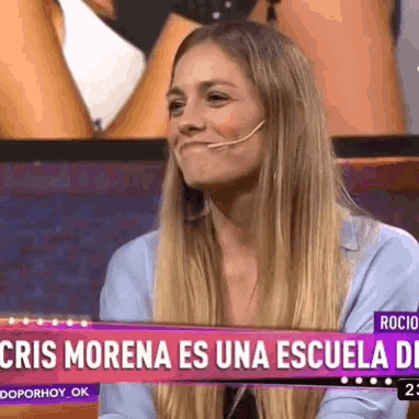 a woman is smiling in front of a sign that says cris morena es una escuela de