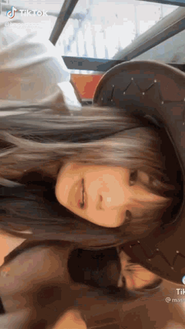 a woman wearing a cowboy hat is making a funny face