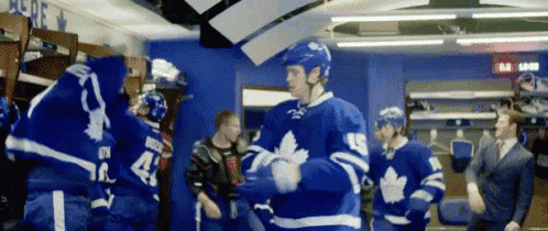 a group of hockey players standing in a locker room