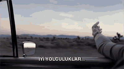 a person 's hand is sticking out of a car window with the words iyi yolculuklar written on the side .