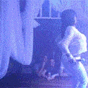 a blurry picture of a person standing in a dark room with a blue light behind them .