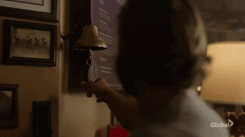 a man is ringing a bell on a wall in a room .