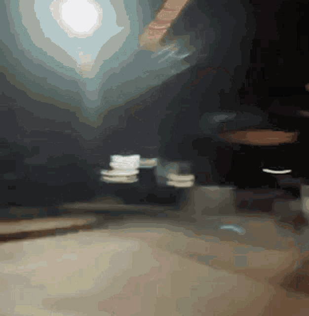 a blurry picture of a street at night with a green sign in the background