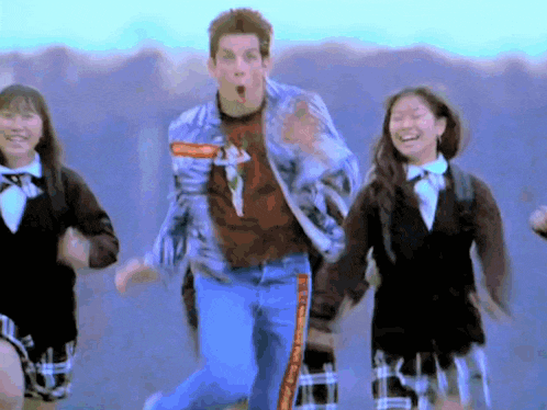 a man in a plaid shirt is running with two girls in school uniforms