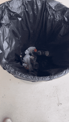 a black garbage bag filled with bottles and trash