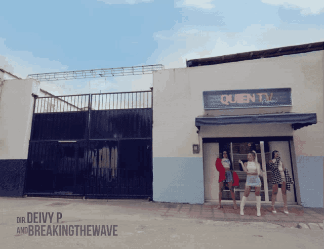 a group of women are standing in front of a queen tv building