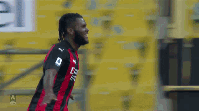 a soccer player wearing a jersey that says emirates on it