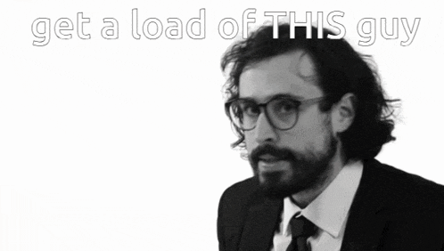 a man in a suit and tie with the words get a load of this guy behind him