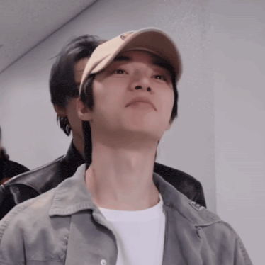 a man wearing a hat with the letter e on it looks up