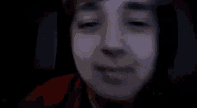 a close up of a person 's face in the dark