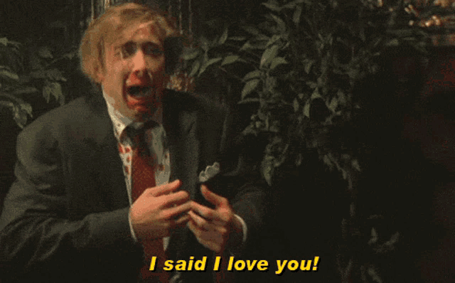a man in a suit and tie with blood on his face says i said i love you