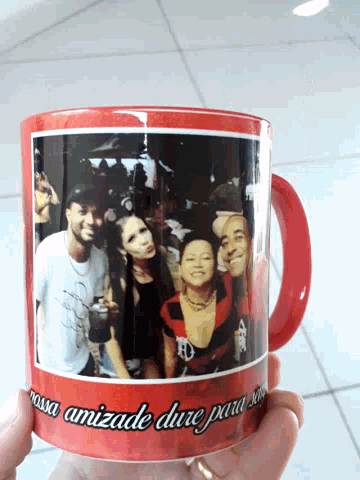 a person is holding a mug with a picture of a group of people on it