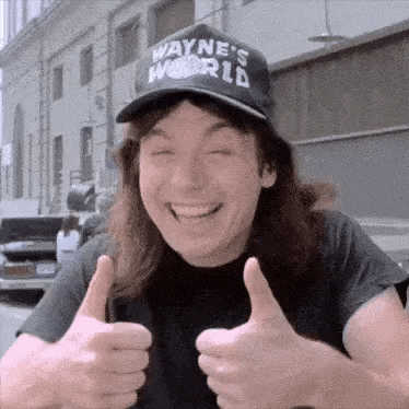 wayne 's world is smiling and giving two thumbs up .