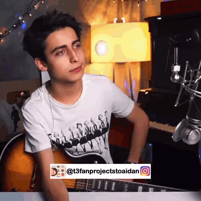 a young man is playing a guitar in front of a microphone with a t3fanprojectstoaidan watermark