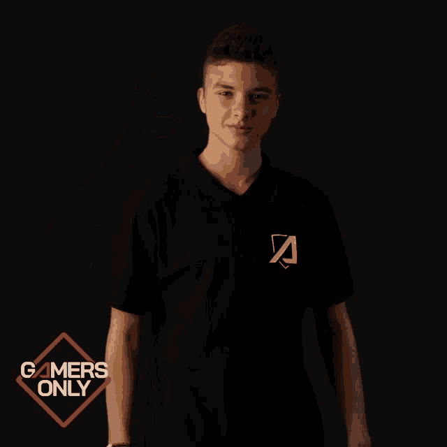 a young man in a black shirt with the letter a on it giving an ok sign