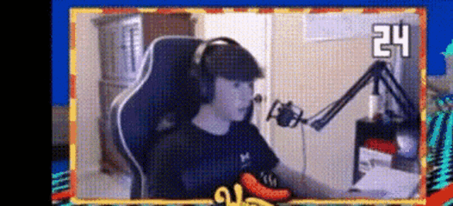 a man wearing headphones is sitting in front of a microphone in a room .