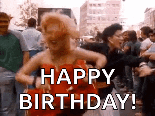 a woman in a red dress is dancing in a crowd with the words happy birthday written on the bottom