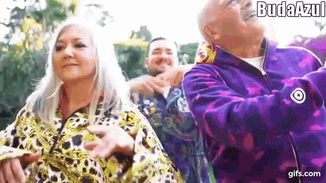 a group of people are standing next to each other and one of them is wearing a leopard print jacket .