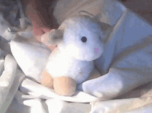 a person is holding a stuffed animal that looks like a rabbit