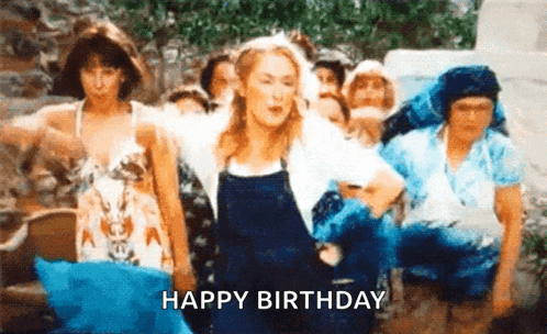 a woman in overalls is dancing in front of a group of people and the words `` happy birthday '' are written below her .
