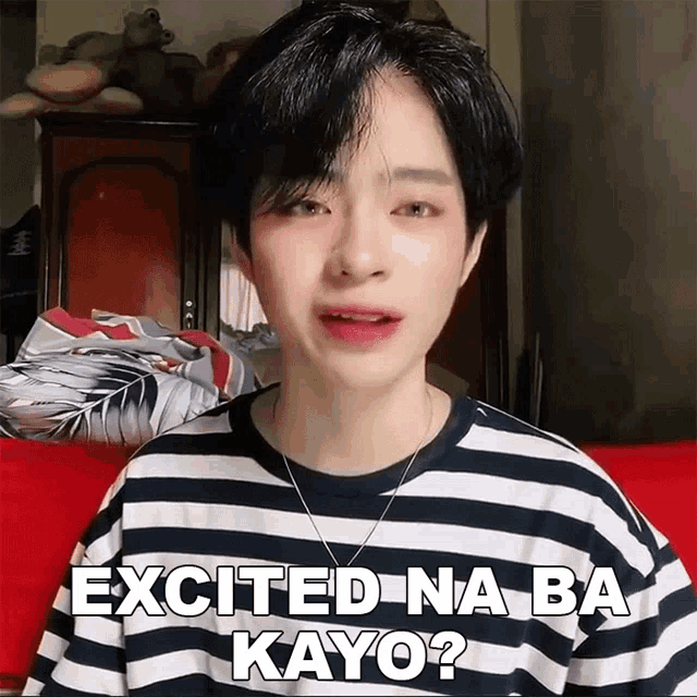 a young man wearing a striped shirt is saying excited na ba kayo
