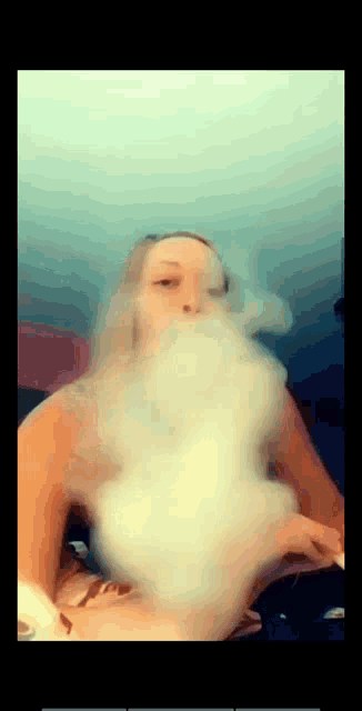 a woman blowing smoke out of her mouth while sitting on a bed