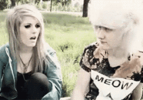 a woman wearing a meow shirt sits next to a man