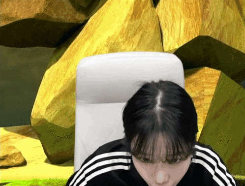 a woman in a black and white adidas jacket sits in a white chair