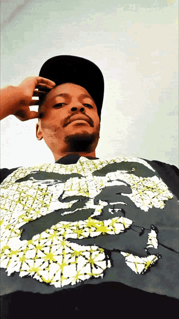 a man wearing a hat and a t-shirt with a picture of a face on it