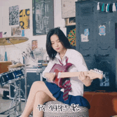 a girl in a school uniform is playing a guitar in a room