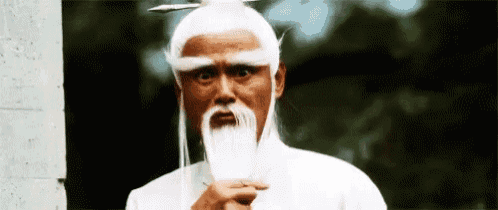a man with a white wig and a long beard is holding a sword .