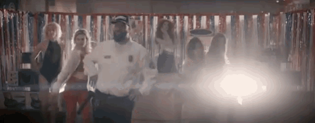 a man in a police uniform is standing next to a group of women .