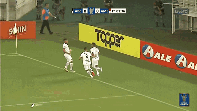 soccer players on a field with a banner that says topper on it
