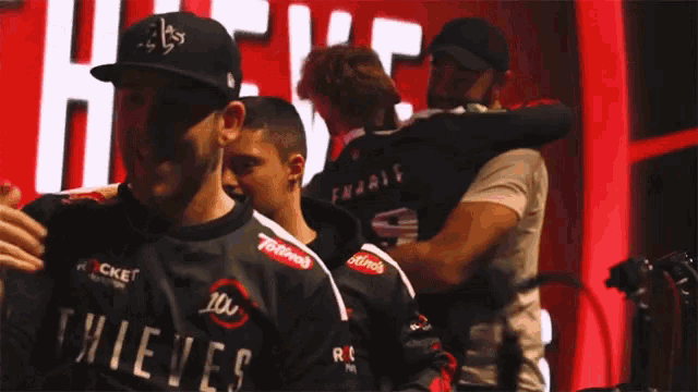 a man wearing a thieves jersey hugs another man