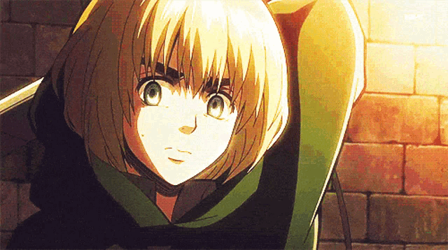 a girl with blonde hair and green eyes is wearing a green hoodie