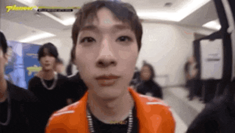 a close up of a man 's face with a group of people behind him .